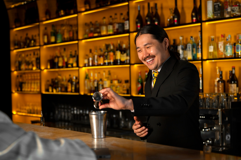 Smiling asian bartender preparing a drink