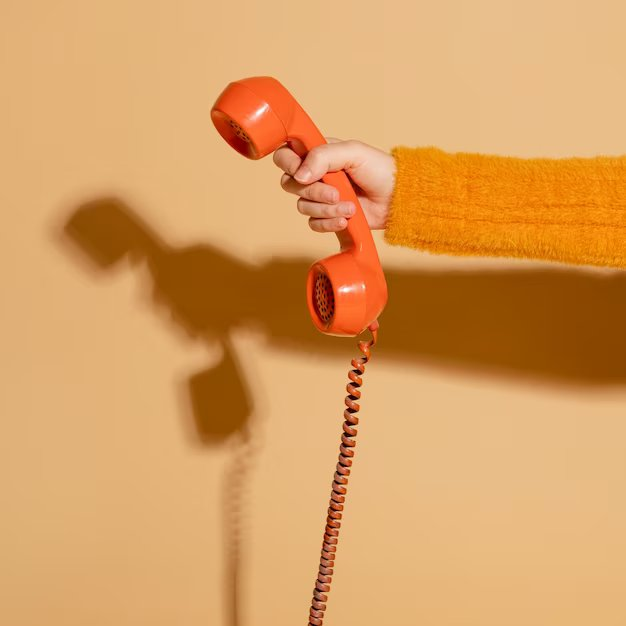 Orange telephone on hand