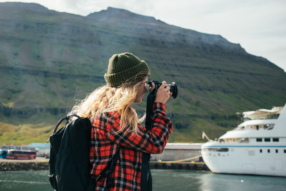 Woman taking a photo of a cruise ship