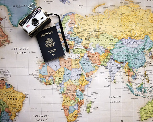 Passport and a camera on top of the world map