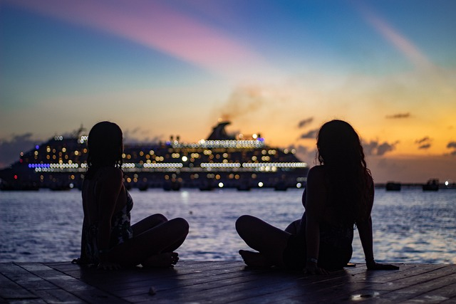 two women enjoying the sunset in front of a cruise