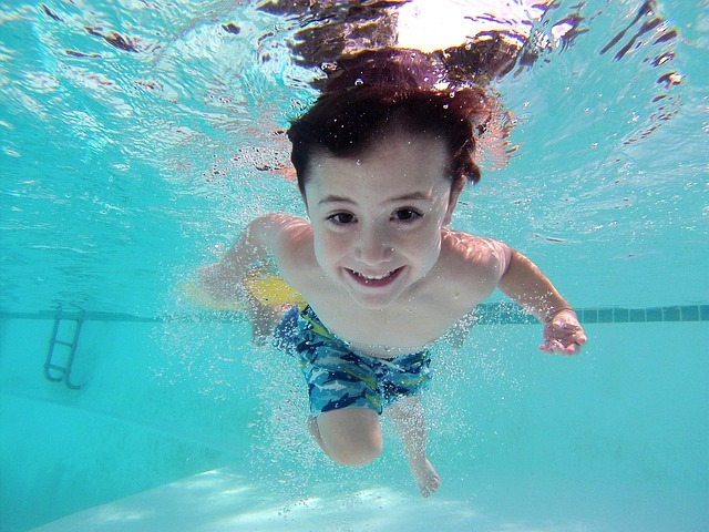 Boy swimming in a pool smiling