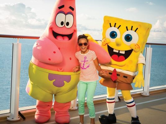 Girl posing between Patrick Star and Spongebob Squarepants mascots