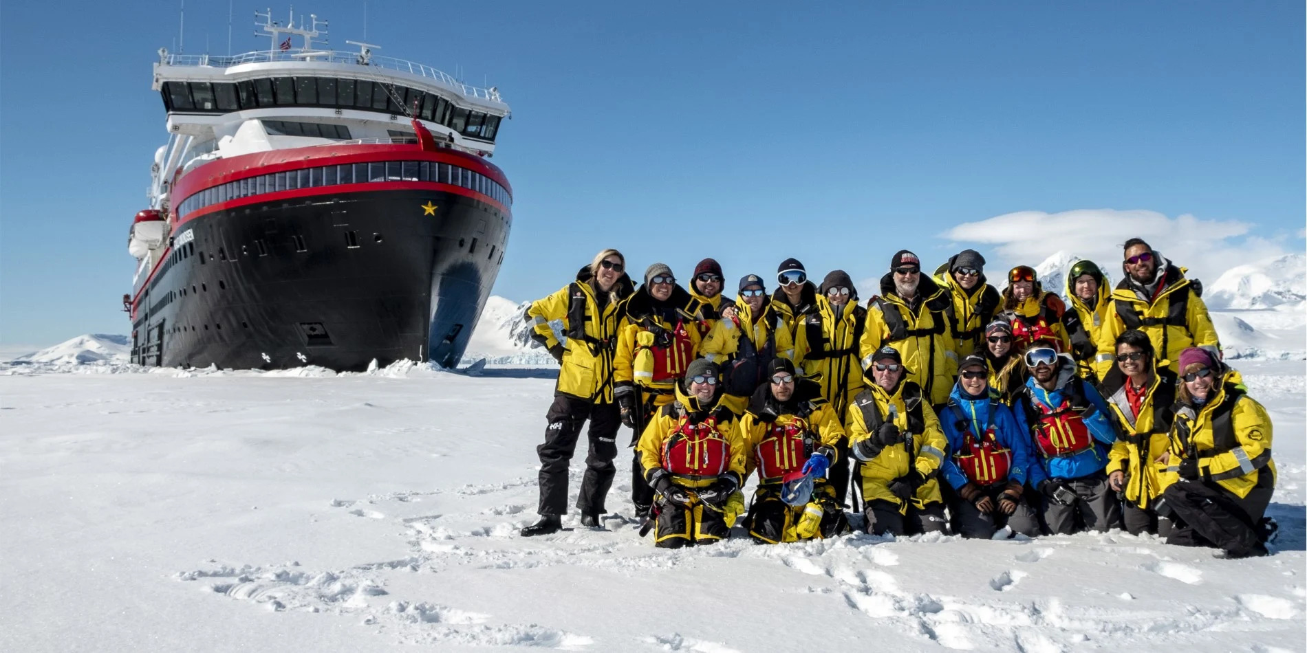 People posing for a photo in front of Hurtigruten ship
