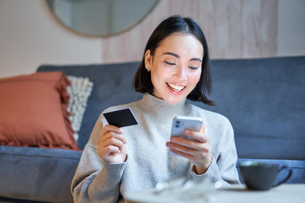 Woman holding a phone and credit card smiling