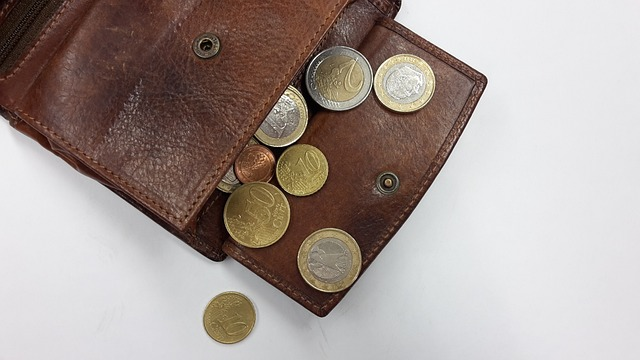 coins falling out of a brown wallet