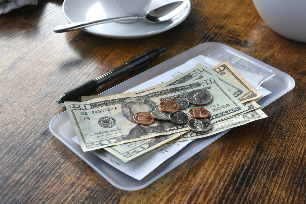 dollar bills on a tray beside a pen