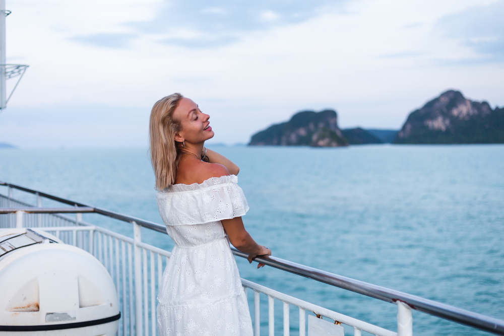 woman wearing a white dress on a cruise deck