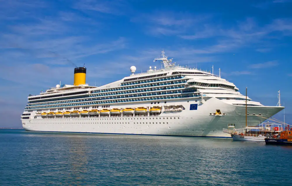 cruise ship on the ocean with a yellow chimney