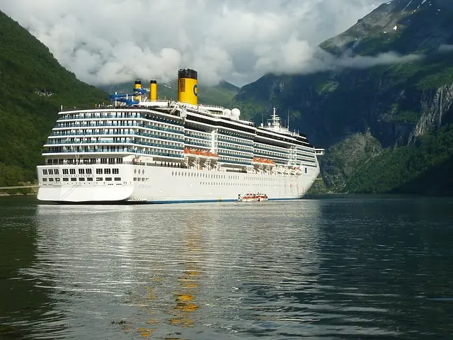 cruise ship with a small boat beside and yellow chimney