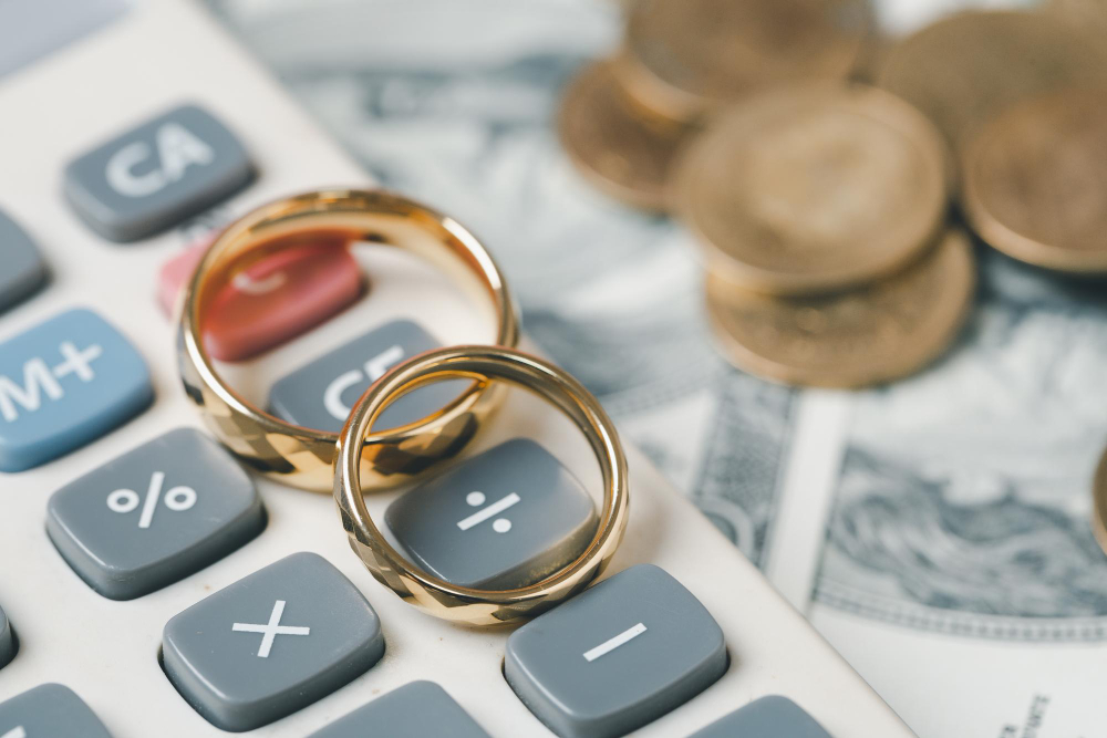 gold wedding rings on top of a calculator