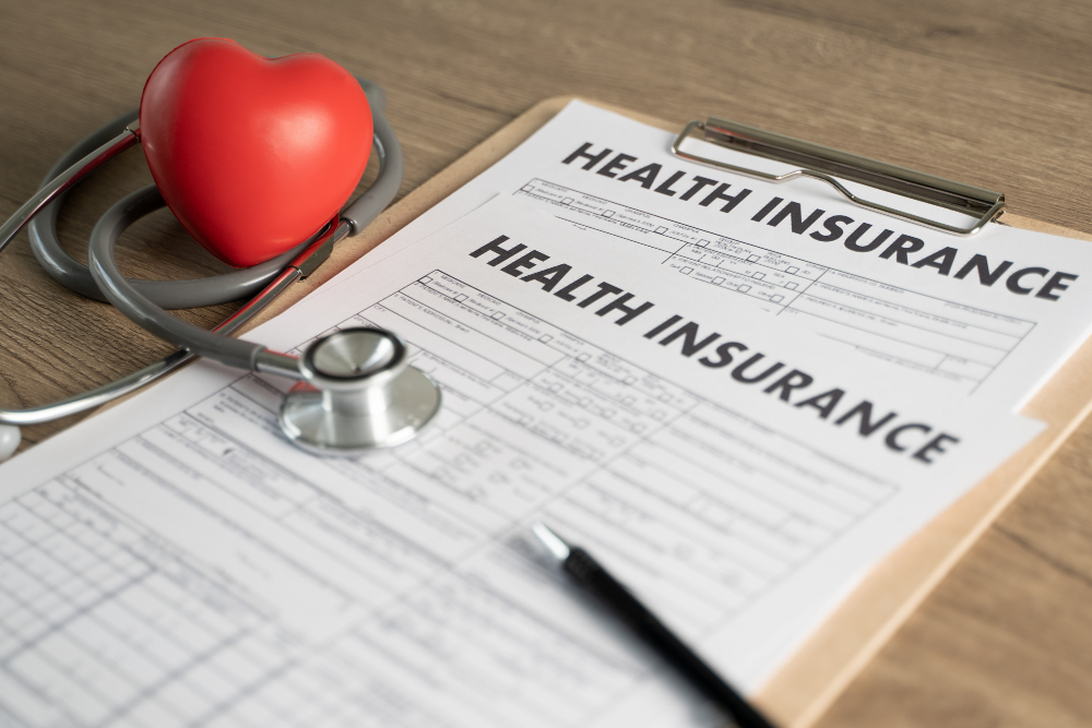 health insurance forms beside a stethoscope