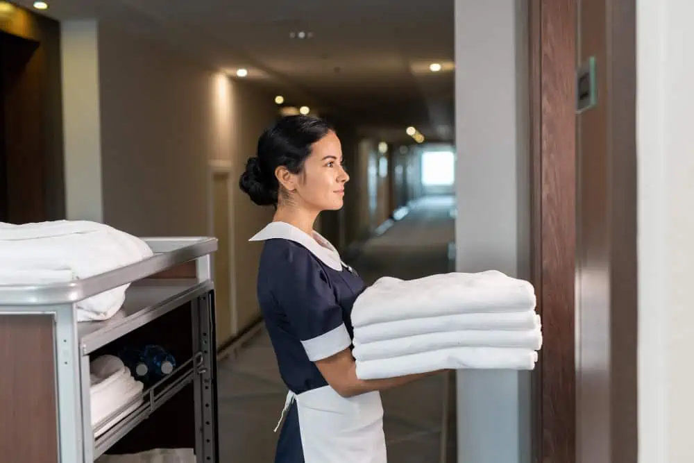 hotel chambermaid giving out fresh towels