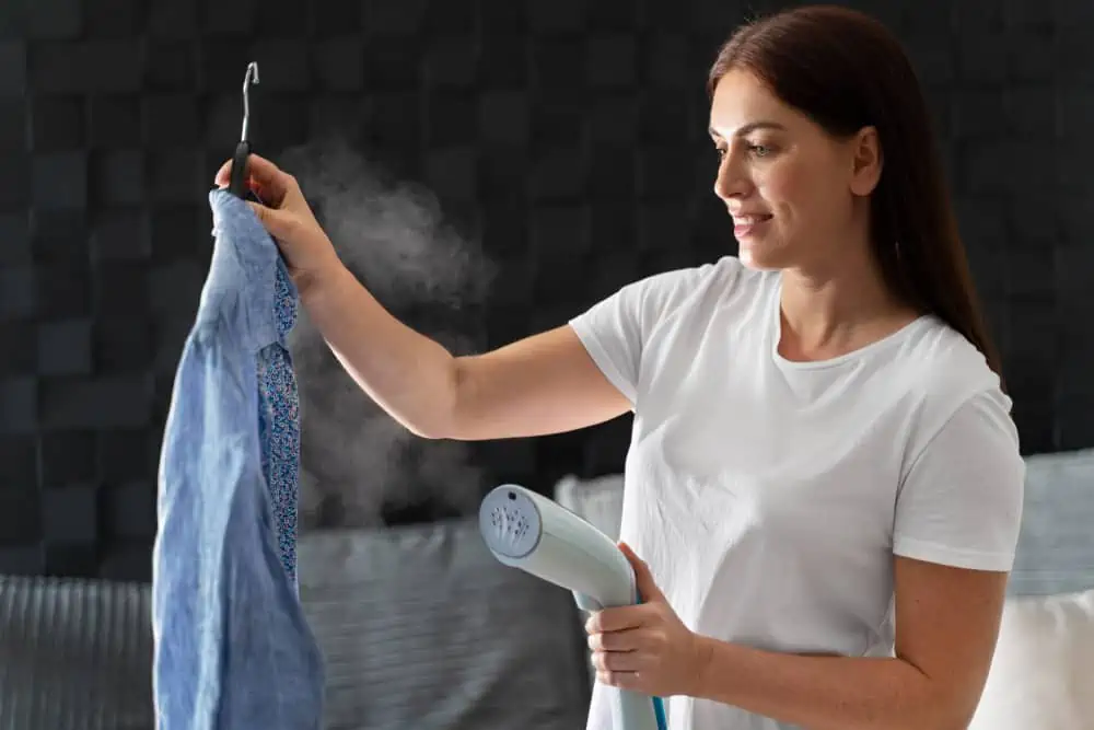 woman steaming a blue longsleeves shirt